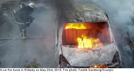 燃える車を消火している消防士
