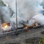 暴動による放火で炎を上げる乗用車（ロイター）